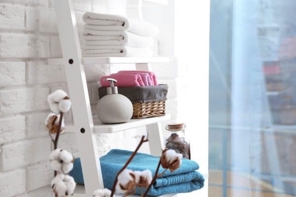 bathroom ladder with towels, soap and a wicker basket