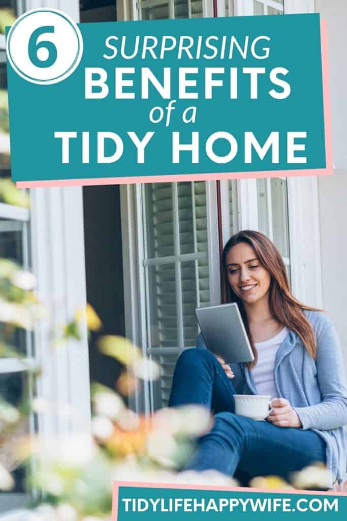 smiling woman sitting in window seat of her tidy home reading and drinking coffee