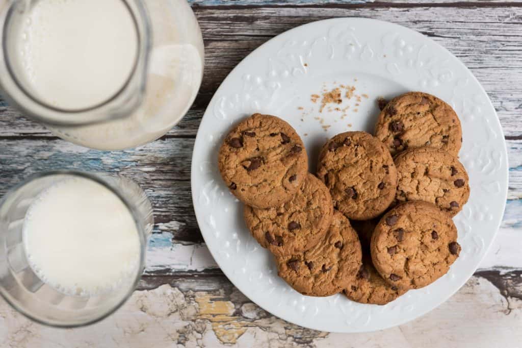 Plate of chocolate chip cookies and two glasses of milk