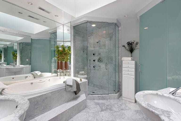 Clean tub, sink and toilet in a marble master bathroom