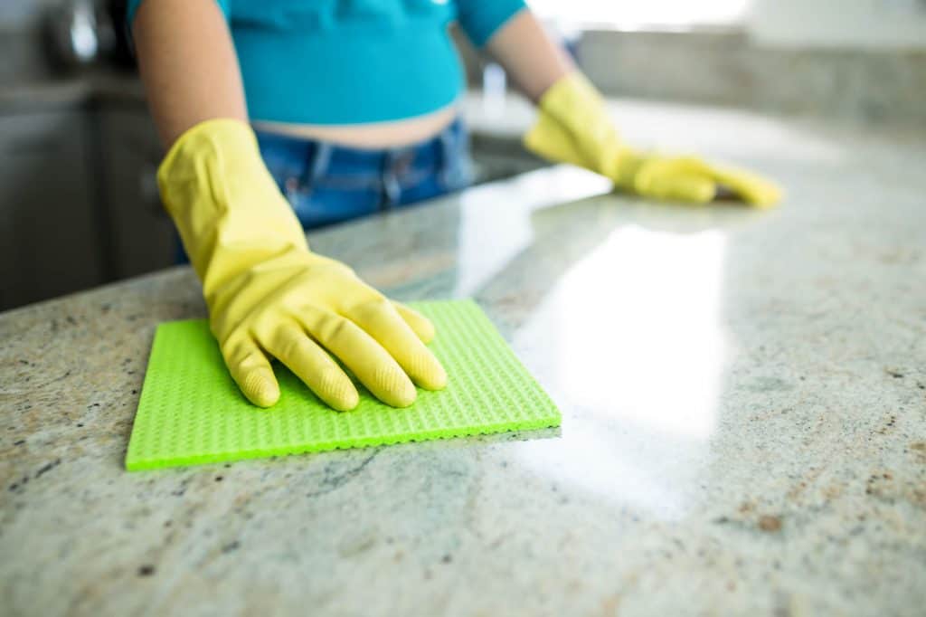 woman cleaning granite countertop