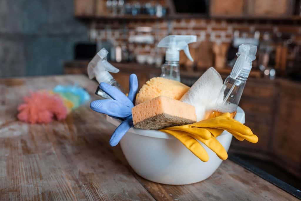 basket of cleaning supplies with a duster