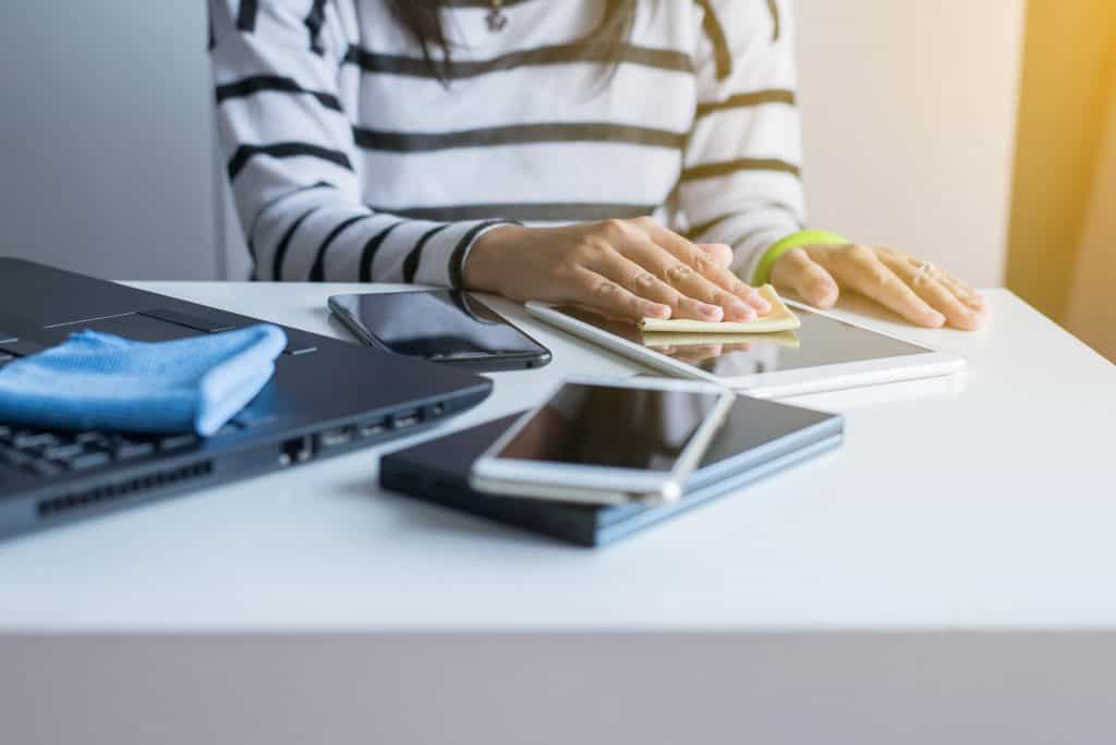 woman cleaning phone and tablet which most people forget to clean