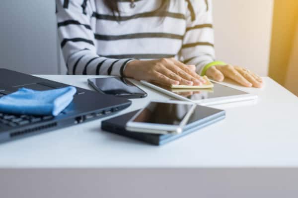 woman cleaning electronic screens with microfiber cloth instead of vinegar