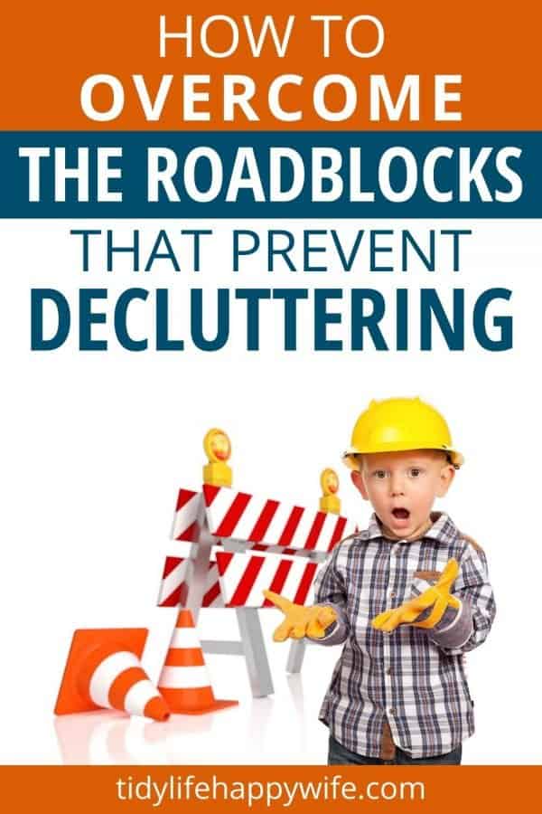 Shocked little boy wearing a hard hat standing in front of a roadblock and construction cones