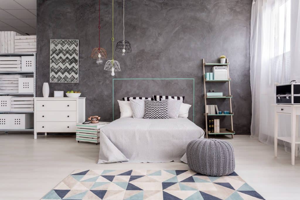 gray bedroom with dressers and shelving for extra storage