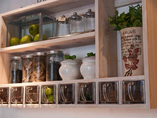 kitchen wall rack with glass jars used to store spices and fruits