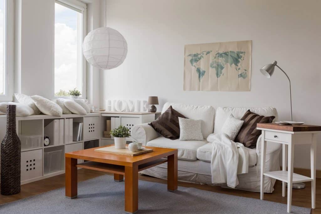 decluttered living room with white couch, coffee table and modular storage