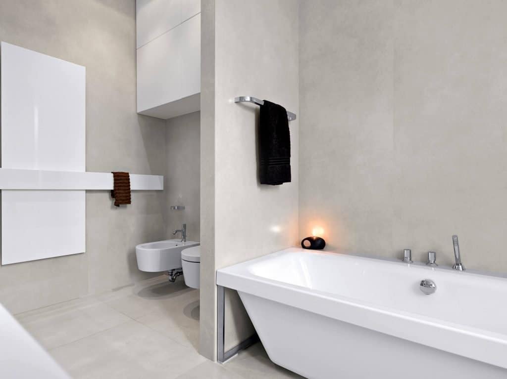 beige and white clutter free bathroom tub, toilet and cabinets