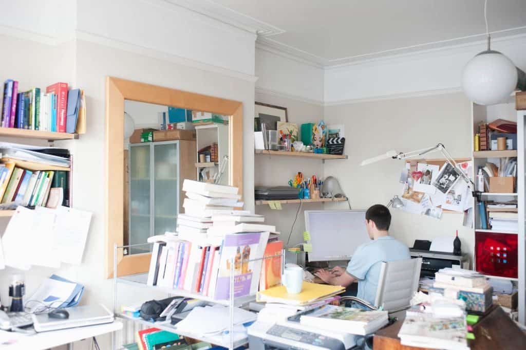 home office full of paper clutter stacks