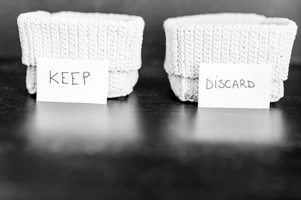 sorting baskets labeled 'keep' and 'discard' used during decluttering