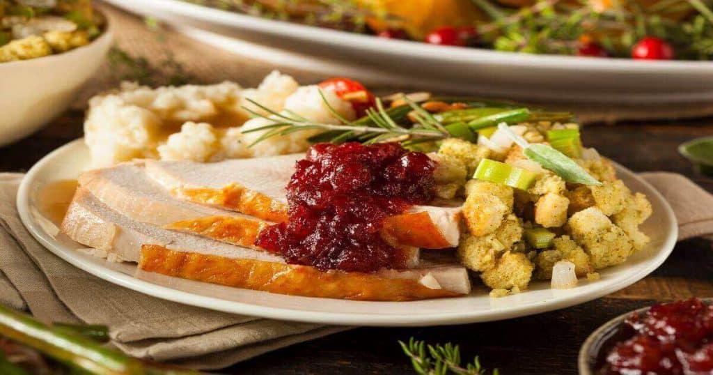 thanksgiving dinner plate with turkey, mashed potatoes, dressing, and cranberry sauce