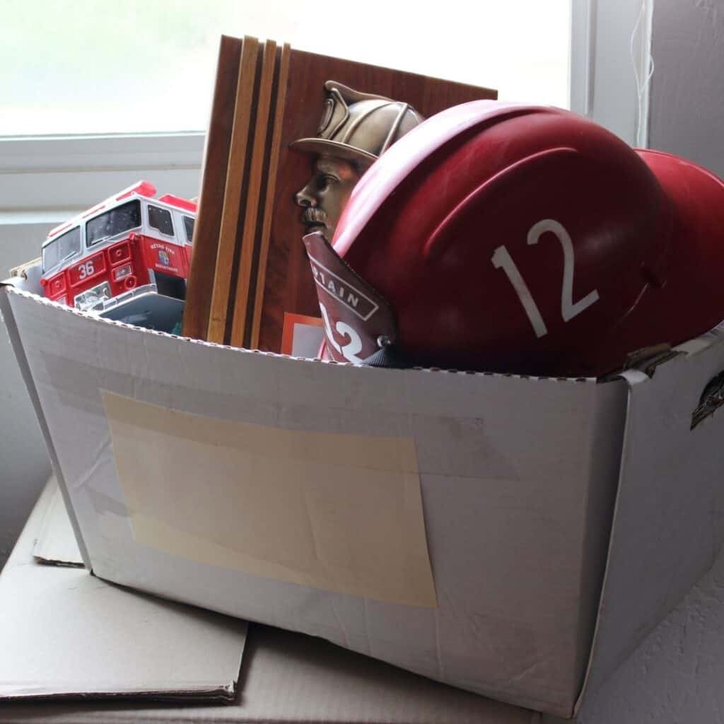 kids toys and memorabilia in a carboard box