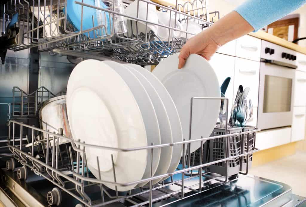 loading dishes in dishwasher to clean kitchen
