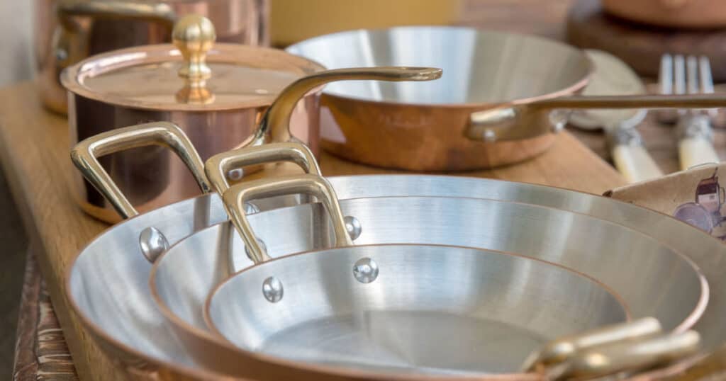 copper pots and pans organized on countertop