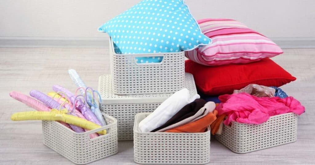 white plastic organizing baskets that are too small and overflowing with stuff