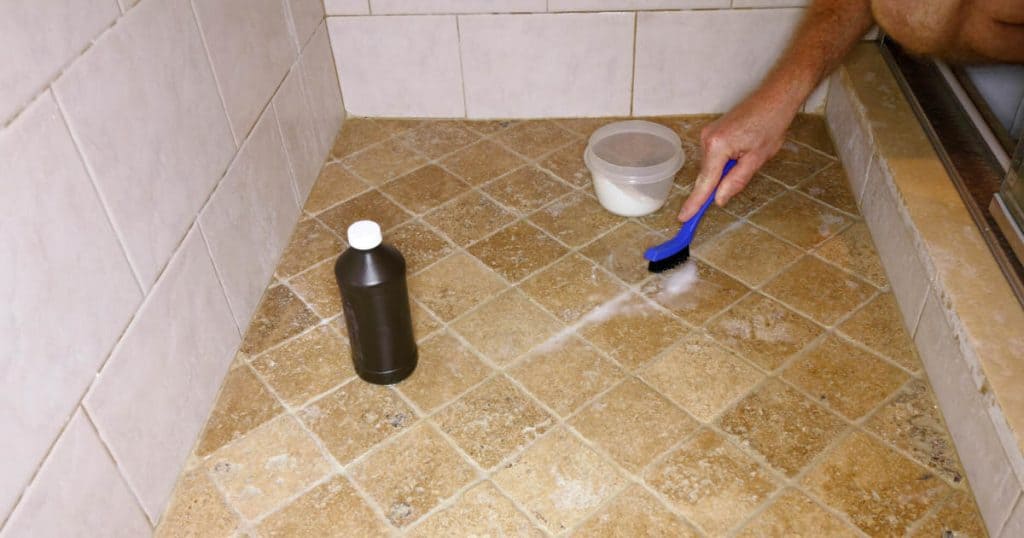 using baking soda and hydrogen peroxide to clean the grout in a tile shower